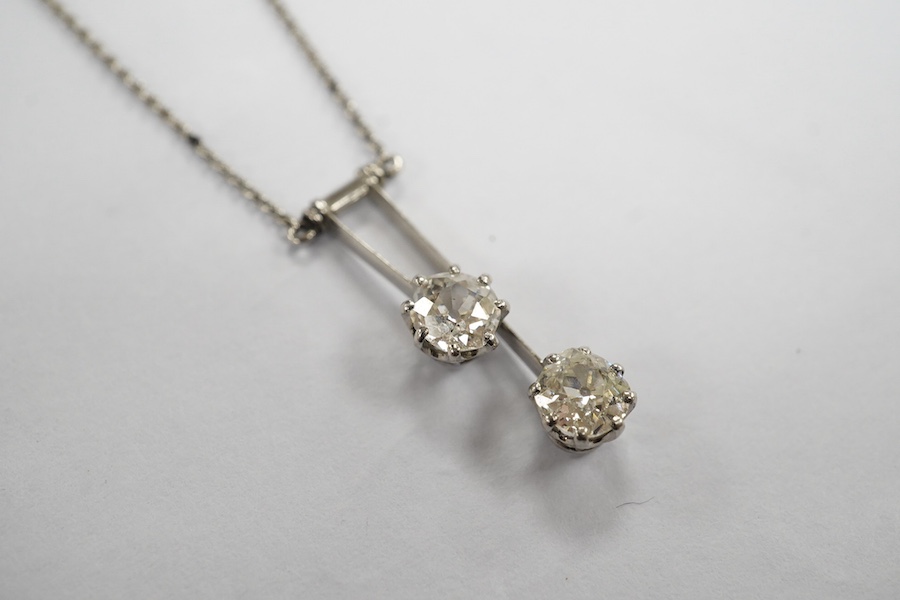 A two stone diamond articulated pendant, on a fine white metal chain. Condition - fair